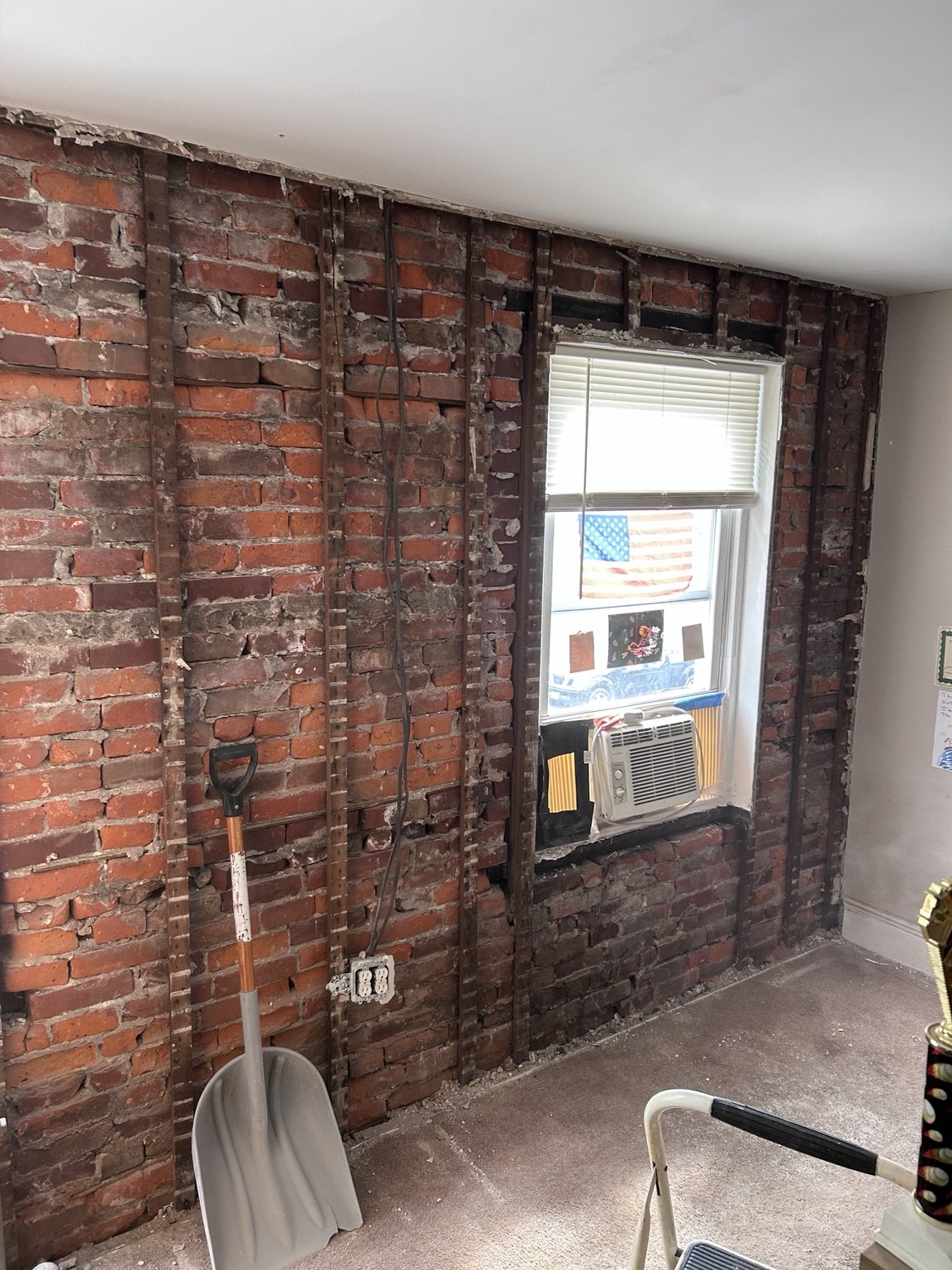 Wall stripped to brick and framing after selective demolition